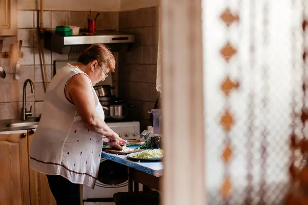 01.03.22 Bar, Ukraine: photo of a village woman preparing food in her kitchen