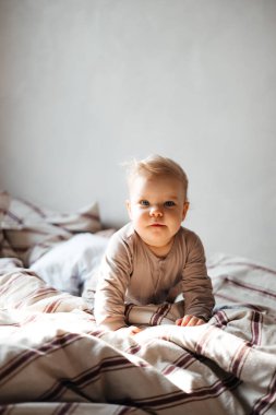 Küçük kız evde giysileriyle yerde oynuyor kitaplar ve oyuncaklar arasında, günlük rutin çocuk.