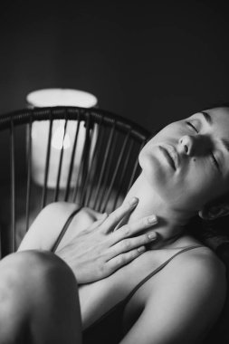 Yatak odasında fotoğraf çektirmek için sıradan bir iç çamaşırı giymiş genç bir kadının portresi. Kozmetik ve plastiksiz gerçek kadın güzelliği