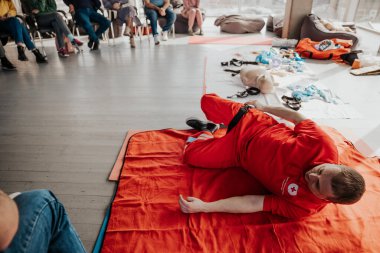26.03.2022 Kyiv, Ukraine: People learning how to safe a life when a person is injured or unconscious is choked sitting together with instructor during the first aid training indoors