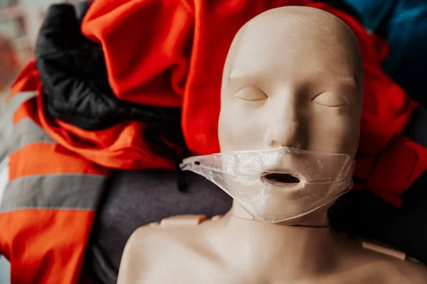 close up: ife size training dummy model, doll face, detail, mannequin mouth wide open, medical equipment. Paramedic class training simple props abstract concept