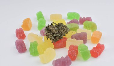 Jellys and marijuana flowers on a white background with copyspace.