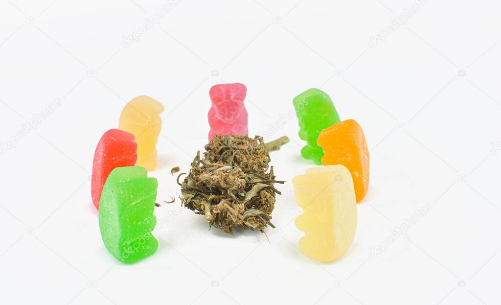 Jellys and marijuana flowers on a white background with copyspace.