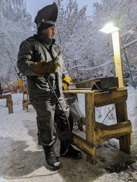 Elektrikli kaynakçı kışın çalışır. Kışın metalle çalışmak. Bir adam metal kaynıyor..