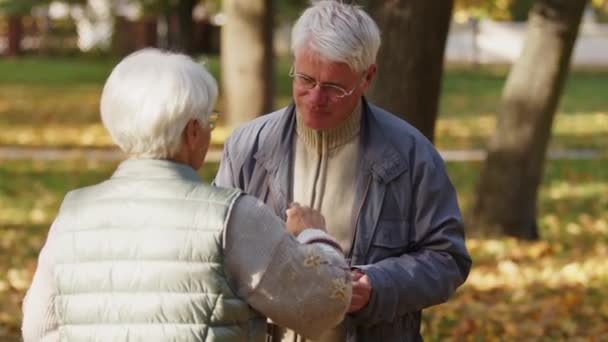 Благотворительное мероприятие. Старуха, доброволец, дающий горячую еду пожилому мужчине — стоковое видео