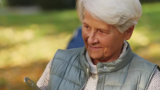 Ein alter Mann gießt einer älteren Frau im Freien einen Teil der warmen Mahlzeit ein. Wohltätigkeit und soziale Fürsorge — Stockvideo