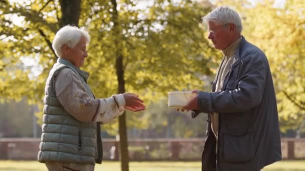 Evento de caridad. Hombre voluntario dando una comida caliente a una anciana — Vídeo de stock