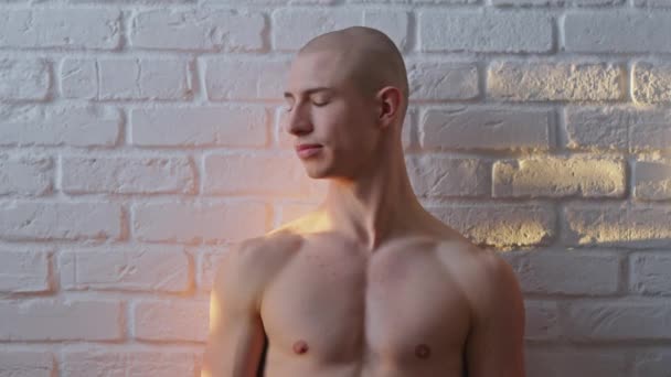 Молодий лисий без сорочки красивий гомосексуальний чоловік позує над білою стіною. Концепція вираження сексуальності — стокове відео