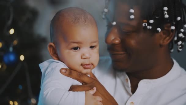 Prima il Natale del bambino. Papà e neonato giocare circondato comprare scatole regalo rosso e cappello di Babbo Natale — Video Stock