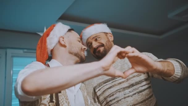 크리스마스를 축하하는 행복 한게 이 커플. 손으로 심장 모양을 만든다 — 비디오