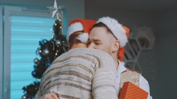 Julklappsutbyte i homosexuell familj. Snygga vackra homosexuella manliga par firar jul — Stockvideo