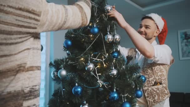 Dekoracja choinki. gej mężczyzna para mając zabawy dekorowanie Boże Narodzenie drzewo — Wideo stockowe
