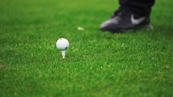 Närbild av en tee shot. Man svänger och slår en golfboll — Stockvideo