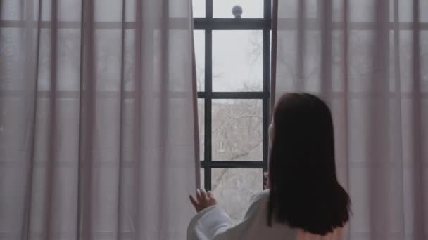 Ung kvinna njuta av morgon openig fönster gardiner - medium skott — Stockvideo