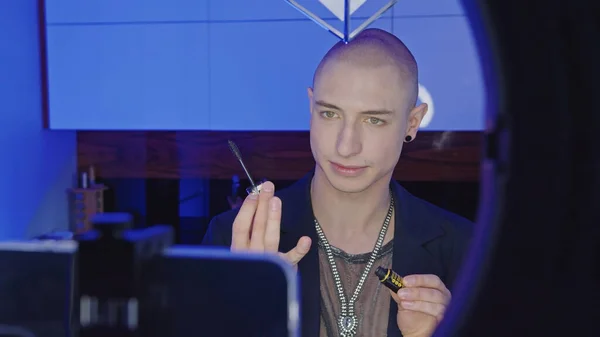 Non-binary European person learns how to do their makeup and puts mascara on eyelashes from video tutorials in the bathroom — Stock Photo, Image