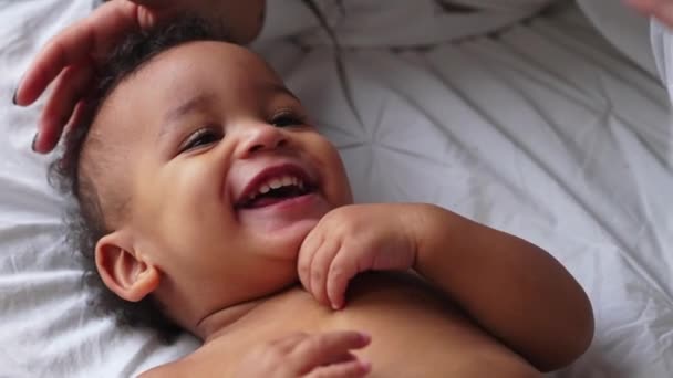 Divertido biracial criança sorrindo e rindo com seus pais enquanto deitado na cama. — Vídeo de Stock