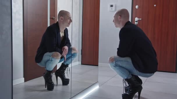 Queer bald schöner schwuler Mann hockt, während er extrem gotische schwarze High Heels trägt und sein Outfit überprüft — Stockvideo