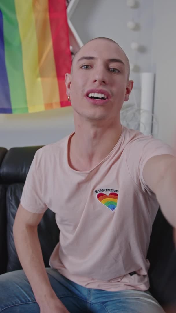 Vertikale Aufnahme eines europäischen schwulen Aktivisten mit Glatze, der mit seinem Smartphone mit seinen Online-Followern spricht. — Stockvideo