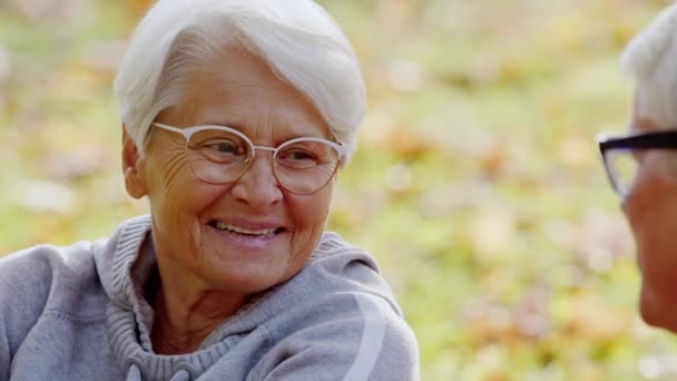 Открытый портрет пожилой пенсионерки, разговаривающей с мужем в парке — стоковое видео