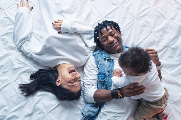 Caucásico morena y su afro-americano pareja vinculación con su niño pequeño bebé. — Foto de Stock