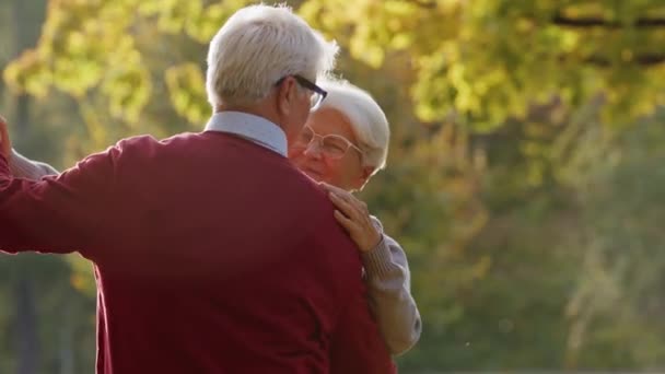 Heureux vieux couple dansant dans le parc d'automne - plan moyen — Video