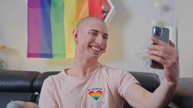 Beyaz, sempatik eşcinsel bir adam kendi fotoğrafını çekiyor ve akıllı telefonuyla internete yüklüyor..