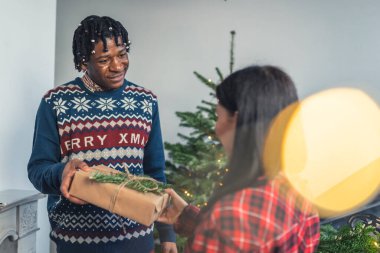 40 'larında Afro-Amerikalı bir adam Noel arifesinde karısına hediye veriyor..