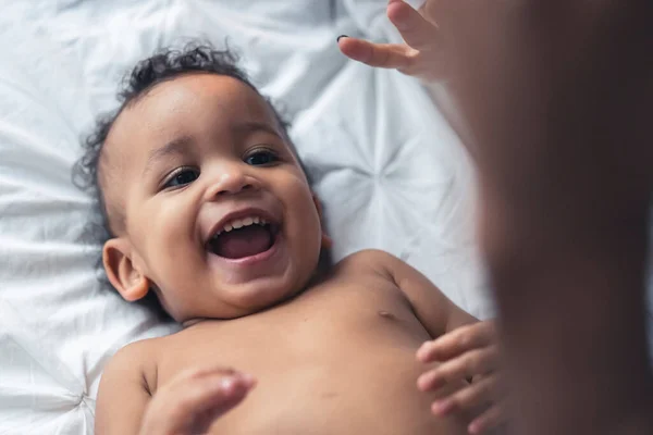 Sevimli melez bebek yere yatıp gülümsüyor. Mutlu çocukluk kavramı. — Stok fotoğraf
