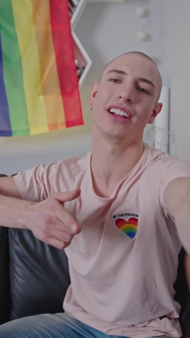 Europäischer Schwulenaktivist, der live über LGBTQAI-Rechte spricht, mit Regenbogenfahne hinter seinem Rücken. — Stockvideo