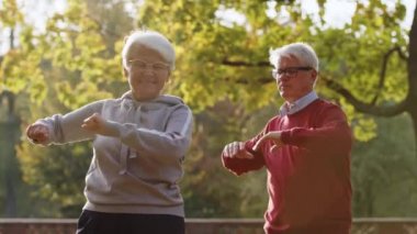 Yaşlı beyaz çift parktaki seçici odak noktasında spor yapıyor. 