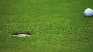 Varşova, Polonya, 09.29.2021 golcü deliğe bir golf topu koyarak gol atıyor.