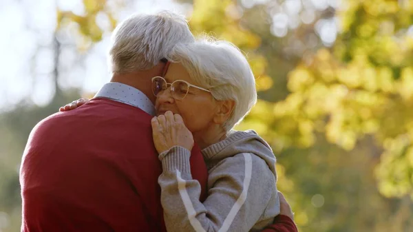 Porträt eines alternden kaukasischen Ehepaares, das sich im Park eng umarmt, Frau schließt die Augen Senioren unterstützen Konzept selektiver Fokuskopierraum — Stockfoto