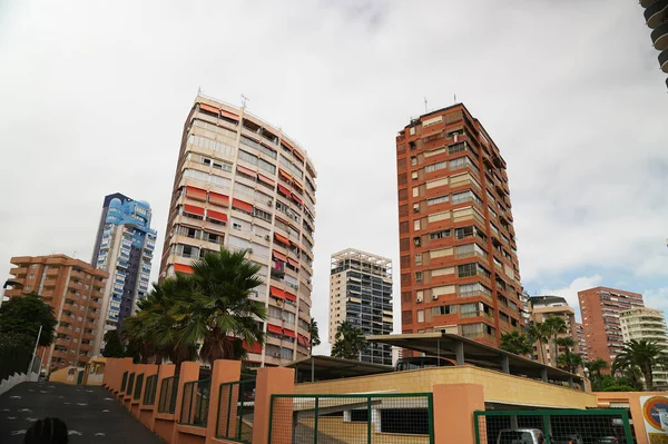 Geniş sokakları olan İspanyol kasabası. Palmiye ağaçları olan bir grup bina..