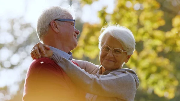 Porträt eines hochbetagten kaukasischen Paares, das sich im Park umarmt Mann blickt seine Frau an und Frau blickt in die Kamera Senioren Wohlbefinden Konzept selektiver Fokus Kopierraum — Stockfoto