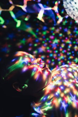 Yatak odasında genç bir çocuk tarafından kullanılan gece lambası projektörü. Dikey çekim.