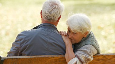 Yaşlı beyaz heteroseksüel çift parkta dinleniyor. İki emekli kır saçlı yaşlının açık hava portresi..