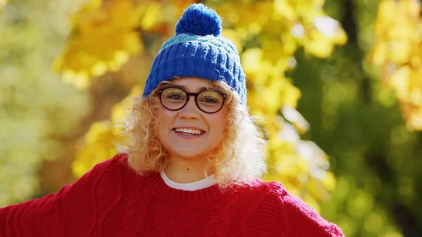 Outdoor shot of an adorable blonde teenage girl with curly hair and dark blue hat. Autumn fall vibes. — Zdjęcie stockowe