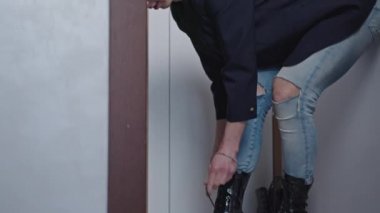 Caucasian bald gay man putting on huge black goth high heels, preparing to go out with friends. High quality 4k footage