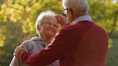 Emekliliğin keyfi. Yaşlı, beyaz, heteroseksüel bir çift. Erkek, karısına nazikçe dokunur. Gri saçlar ve gözlerinin içine bakar..