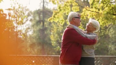  Gri saçlı kadın kocasının saçına, arka plandaki orta boy fotokopi odasına dokunuyor. Yüksek kalite 4k görüntü