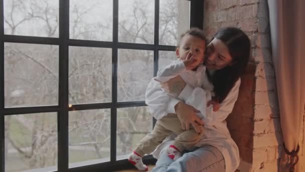 Lindo Niño Enviando Besos Mamá Sosteniendo Hijo Frente Ventana Con — Vídeo de stock