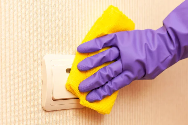 Female hand in a rubber glove disinfects the room switch — Stock Photo, Image