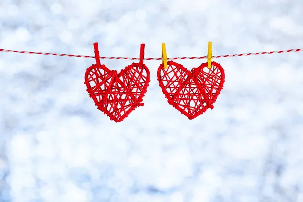 Two Red heart hanging on a rope. Against the backdrop of a blurred shiny white-lipped background. Copy space. Concept Royalty Free Stock Photos