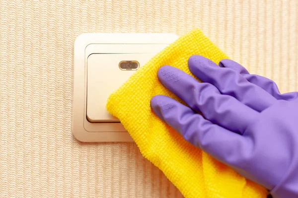 Mano femenina en un guante de goma desinfecta el interruptor de la habitación — Foto de Stock
