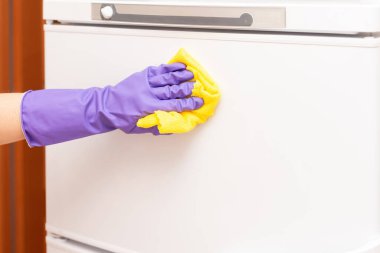 Kadınların elleri beyaz buzdolabının kapısını siler.