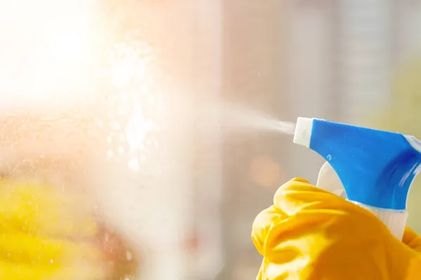 Hand in a yellow rubber glove wipes the window close-up — Stock Photo, Image