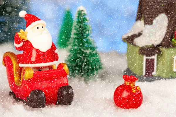 Brinquedo Papai Noel e trenó na neve, abetos artificiais ao redor, cartão de felicitações de Natal — Fotografia de Stock