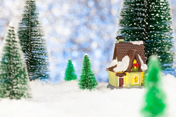 Weihnachtsgrußkarte vorhanden. Kleines Spielzeughaus im Schnee. Künstliche Fichte — Stockfoto