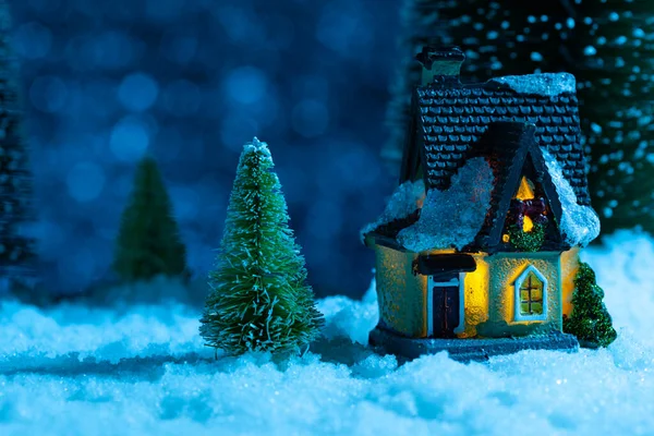 Fabelhaftes Winterhaus im Wald in der Nacht, der Mond scheint, es schneit. Neujahrsgrußkarte — Stockfoto