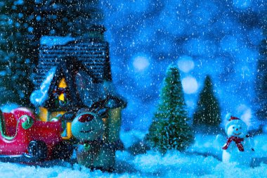 Noel Baba, köy evinin yakınındaki bir kızakta. Kar yağıyor, gece. Yeni yıl tebrik kartı, konsept